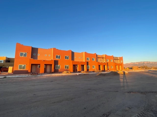 A view of an apartment complex accompanied by a large parking lot, highlighting the ample space for residents' vehicles.